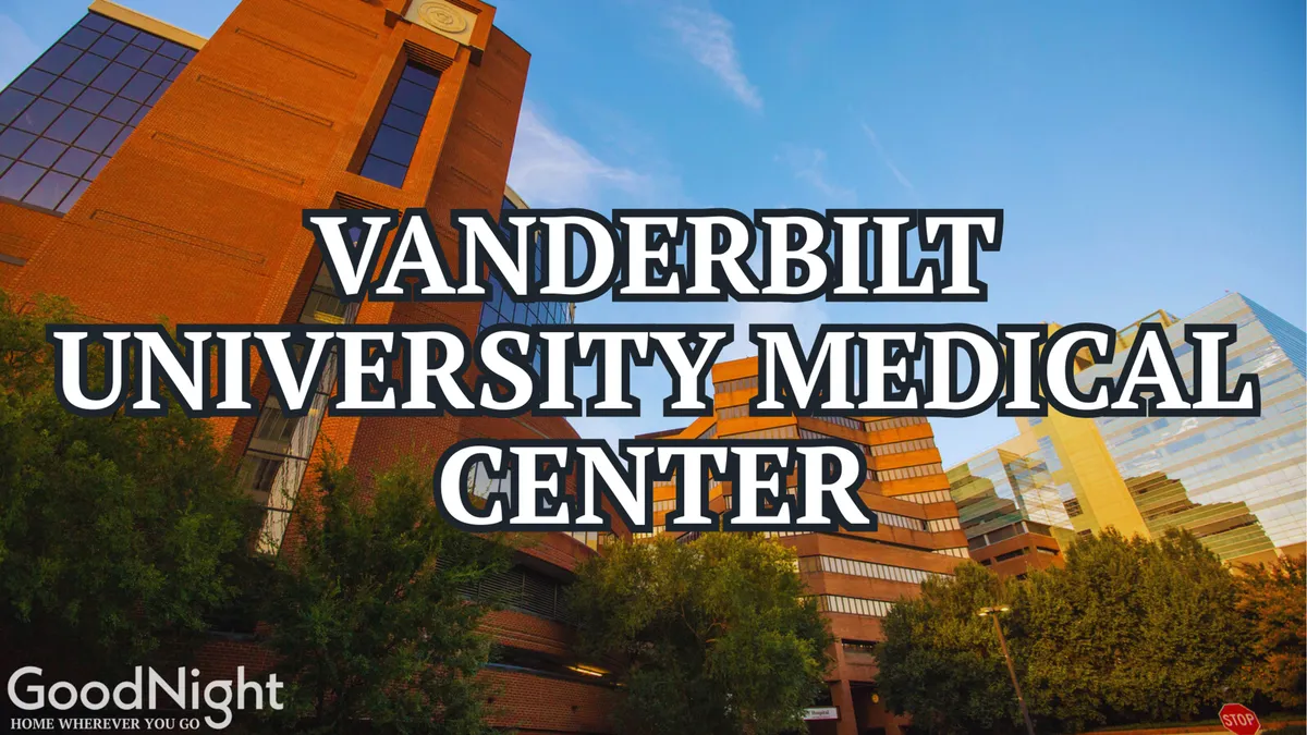 The Vanderbilt University Medical Center building stands tall amidst landscaped greenery under a clear sky, exuding both seriousness and warmth. This modern facility is a regional hub for healthcare and medical research.