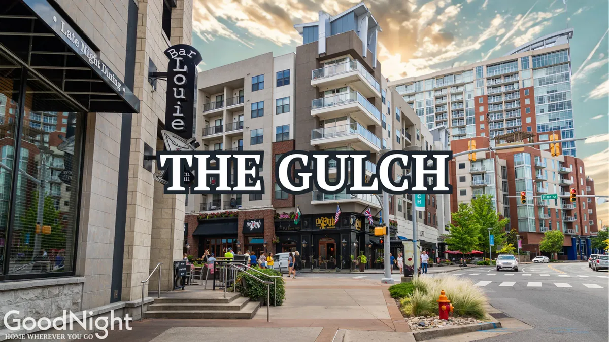 A lively Nashville street scene featuring Bar Louie, bustling with pedestrians and outdoor diners. Residential buildings and street signage set the context for a vibrant, walkable neighborhood. The image captures people enjoying meals, shopping, and socializing along the sidewalk.