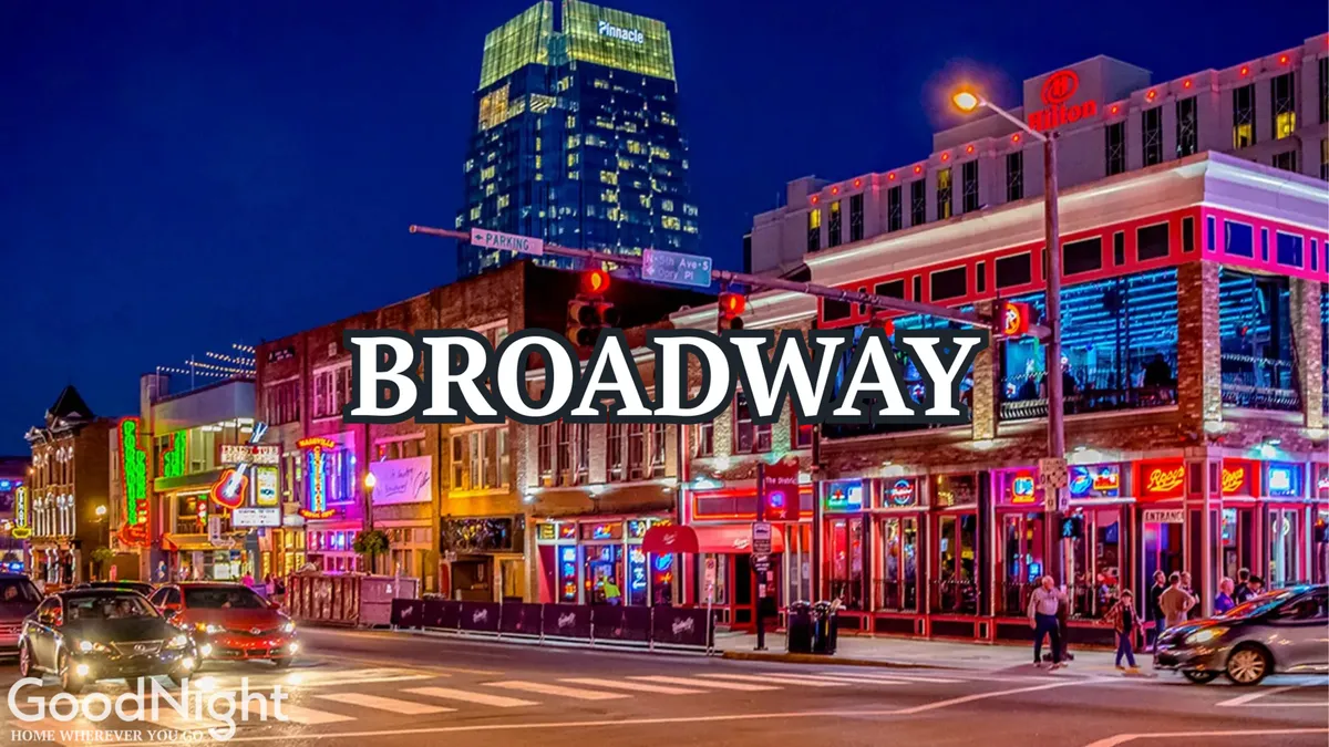 A vibrant Nashville street scene at night, with colorful neon signs, bustling sidewalks, illuminated buildings, and people walking among restaurants, shops, and music venues. The energy and excitement of the city’s nightlife are on full display.